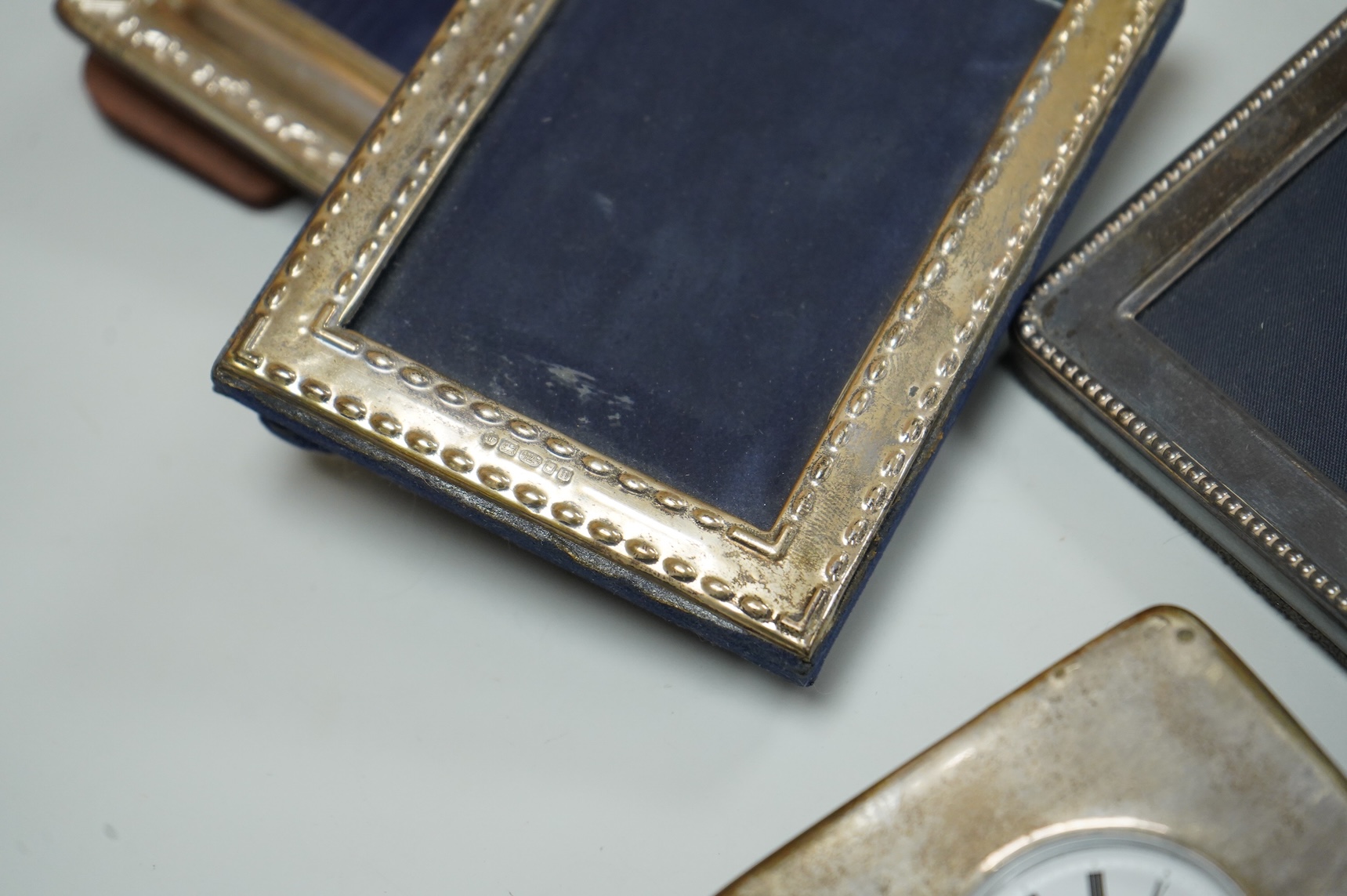 Two modern silver mounted photograph frames, largest 20.4cm by 15.2cm, an Italian 925 mounted photograph frame and a modern silver mounted desk timepiece.